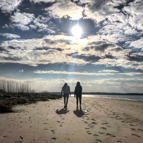 Two friends walking together on a beach