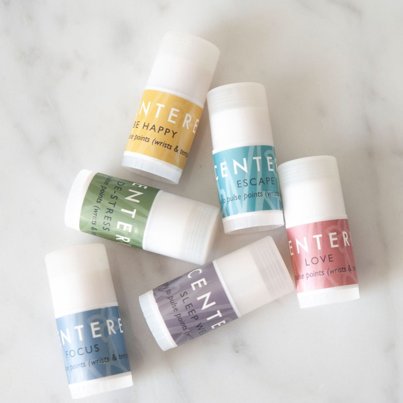 Scentered Sleep Well, Happy, De-stress, Escape, Focus, and Love Mini Balms on a white marble background